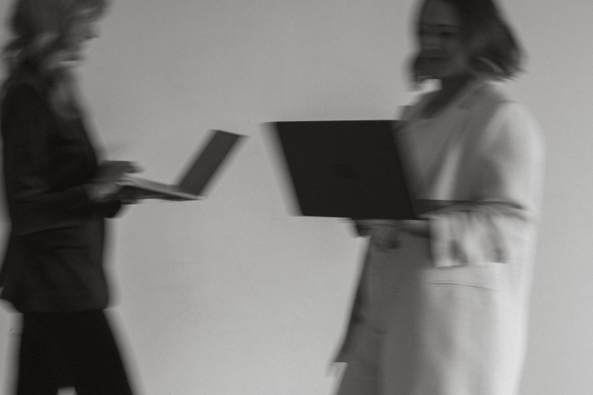 Two strategists in motion, laptops in hand